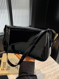 Minimalist black patent leather shoulder bag with magnetic flap and gold hardware accents