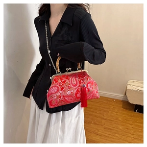 Close-up of red paisley embroidery on the bag with bamboo handle and tassel detail