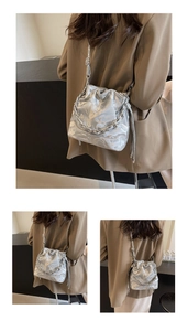 Détail du sac seau argenté avec texture gaufrée et décoration de chaîne métallique