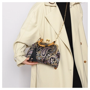 Detail of vintage paisley fabric bag with bamboo handle, silk tassel and metal chain strap