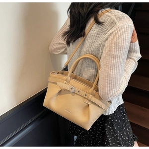 Detailed view of beige lychee grain leather texture and silver buckle on ZANCHETTI handbag