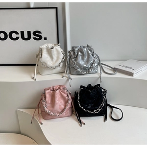 Détail montrant des sacs seaux à cordon en blanc, argent, rose et noir avec chaînes