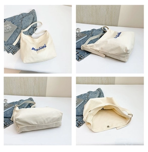 Close-up of cream canvas tote bag with blue malivi embroidery and magnetic closure
