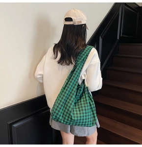 Rear view of a casual outfit featuring a green plaid canvas tote bag for daily use