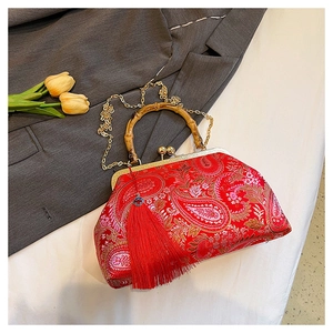 Detail of red brocade bag with bamboo handle, gold chain, and long silk tassel