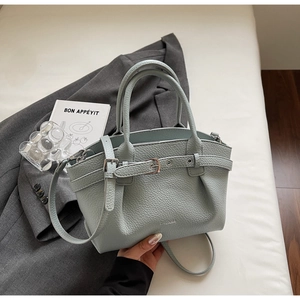 Detailed macro shot of light blue-grey lychee pattern leather and adjustable metal buckle strap