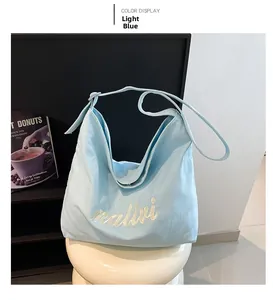 Detail shot of light blue canvas hobo tote bag with embroidered white Ralivi lettering