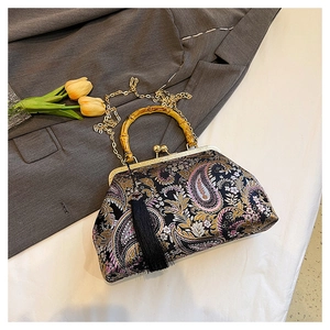 Detailed macro view of vintage paisley jacquard fabric and bamboo handle on the evening bag