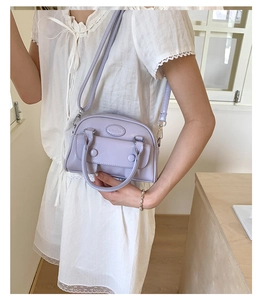 Detail showing lavender handbag with elmelei logo and elegant dual-strap design