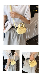 Detail of yellow mini bowling bag featuring a metallic bow accent and long shoulder strap