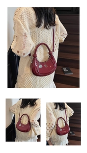Detailed view of burgundy patent leather crescent bag with silver zipper and charm