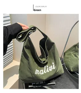 Detail view of military green canvas tote bag with white malivi lettering and wide strap