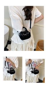 Three-way view of a mini black bowling bag with golden bow and detachable strap