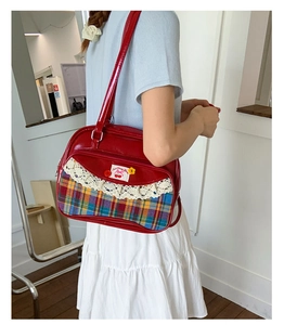 Détail du sac rouge brillant avec tissu à carreaux, dentelle et motif cerise
