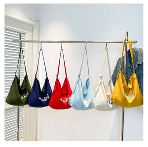 Detailed view of canvas tote bags in six colors with adjustable straps and logo embroidery