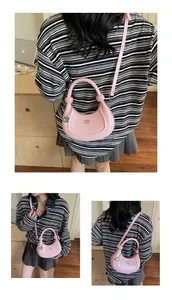 Detail view of pink crescent bag with glossy patent finish and silver chain accessory