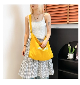 Detail of large yellow canvas hobo bag with muni embroidery and adjustable strap