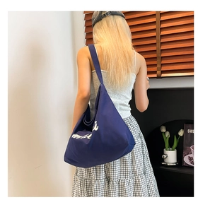 Detailed close-up of dark blue canvas tote bag with white lettering for daily commute