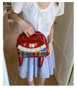 Détail du sac rouge à carreaux avec bordures en dentelle et écusson cerise mignon