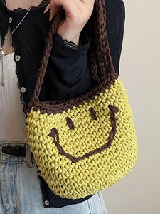 Japanese style yellow knit bucket bag with brown smiley face and woven strap for summer