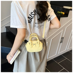 Mini yellow bowling bag with bow detail styled with white T-shirt and grey skirt