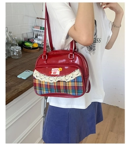 Détail du sac à main en similicuir rouge avec tissu écossais et dentelle délicate