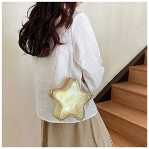 Detailansicht einer glitzernden goldenen Sternen-Tasche mit einem Metall-Kettenriemen
