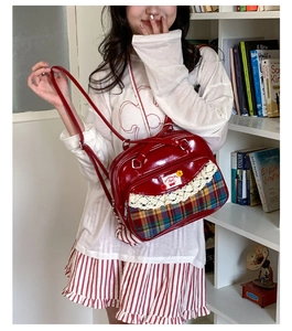 Détail du sac bandoulière en cuir verni rouge avec dentelle et motif à carreaux cerise