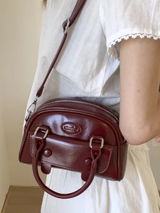 Retro burgundy semi-circle leather handbag with glossy finish and silver hardware details