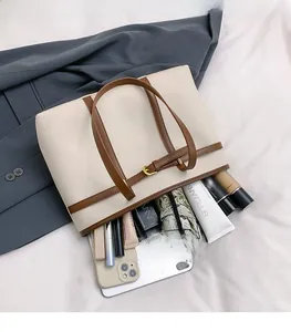 Close-up of cream white leather tote bag showing spacious interior and adjustable straps
