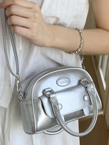 Retro silver metallic handle bag with oval logo and minimalist crossbody strap design