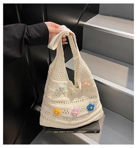 Detailed knit pattern with colorful 3D floral accents on a beige crochet beach tote