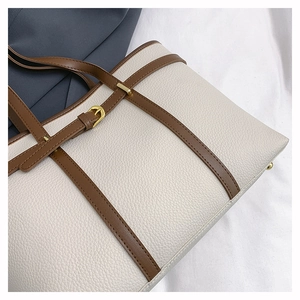 Detailed macro of pebble grain leather and brown strap with gold buckle on tote bag