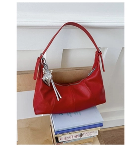 Dettaglio borsa hobo rossa con trama a grana di litchi e ciondolo a cuore argento