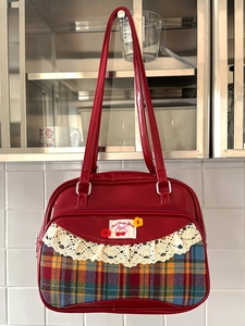 Sac à bandoulière en cuir verni rouge avec motif écossais vintage et détails en dentelle