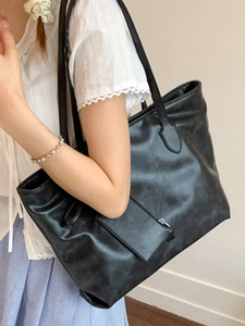 Chic black oversized faux leather tote bag with matching pouch for stylish daily commuting