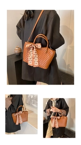 Detail of caramel tote bag with wavy pleats and checkered bow scarf attachment
