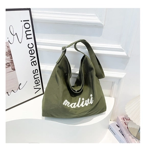 Detail of army green canvas tote bag featuring malivi embroidery on white display stand