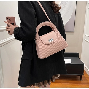 Close-up of pink striped crossbody bag featuring a silver metal twist lock and top handle