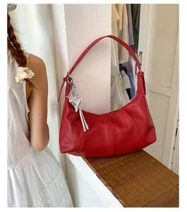 Dettaglio della borsa hobo rossa con trama litchi e ciondolo a cuore in argento
