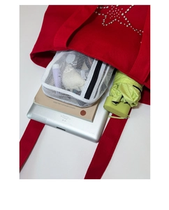 Detail showing high-capacity red canvas tote bag interior with silver star studs