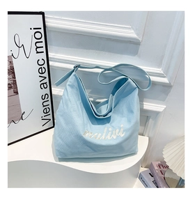 Detail of light blue canvas Hobo bag with white malivi embroidery and wide shoulder strap