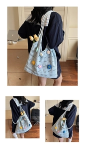 Detail of light blue hollow crochet tote bag featuring colorful 3D flower decorations