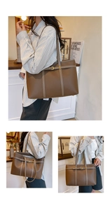 Detail of a brown lychee pattern leather tote bag with gold metal buckle and dual handles