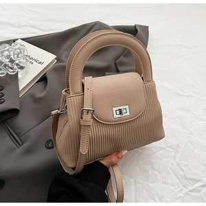 Detailed view of beige crossbody bag showing lychee pattern leather and vertical pleat texture