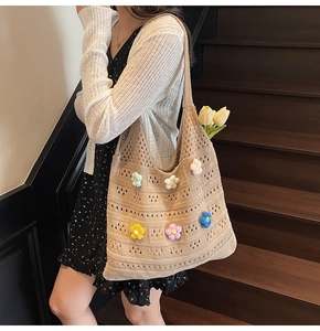 Detail of crochet tote bag featuring 3D knit flowers and hollow weave texture on shoulder