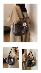 Dettaglio della borsa hobo marrone scuro con ciondolo a pecora e logo dorato