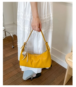 Elegante borsa gialla a forma di gnocco con ciondolo a cuore e trama in pelle litchi
