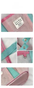 Detail of pink and mint green mesh beach bag showing metal hardware and woven handles