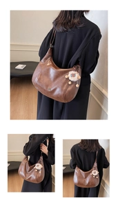 Dettaglio della borsa hobo in pelle marrone con logo CQIH e portachiavi a forma di pecora